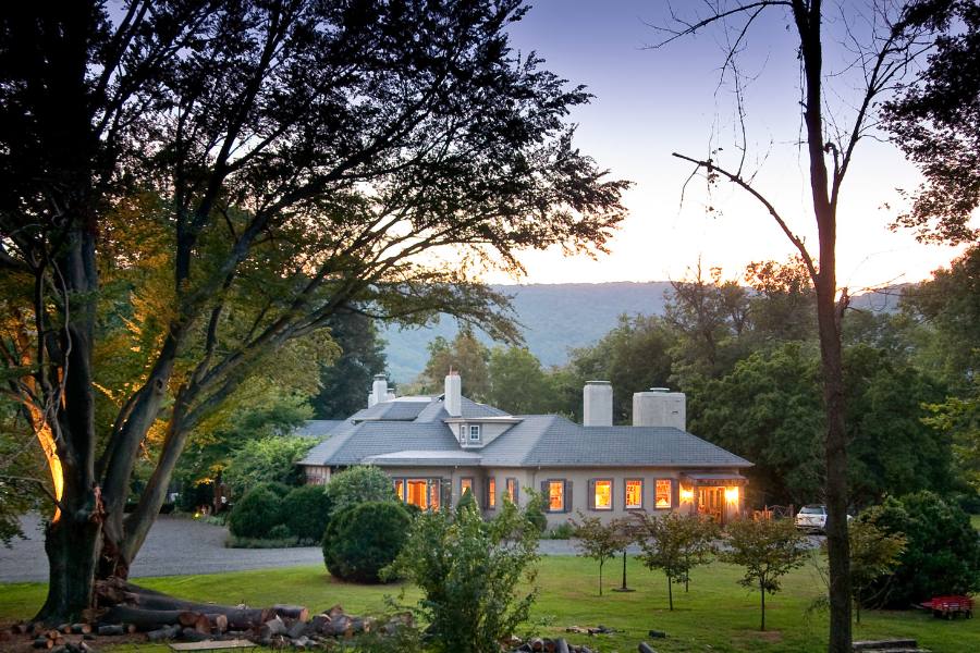 Exterior of Glen Gordon Manor at sunset with a tree in the foreground.