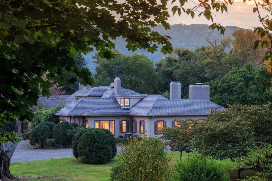 Exterior of Glen Gordon Manor at sunset with warm light shining through the windows
