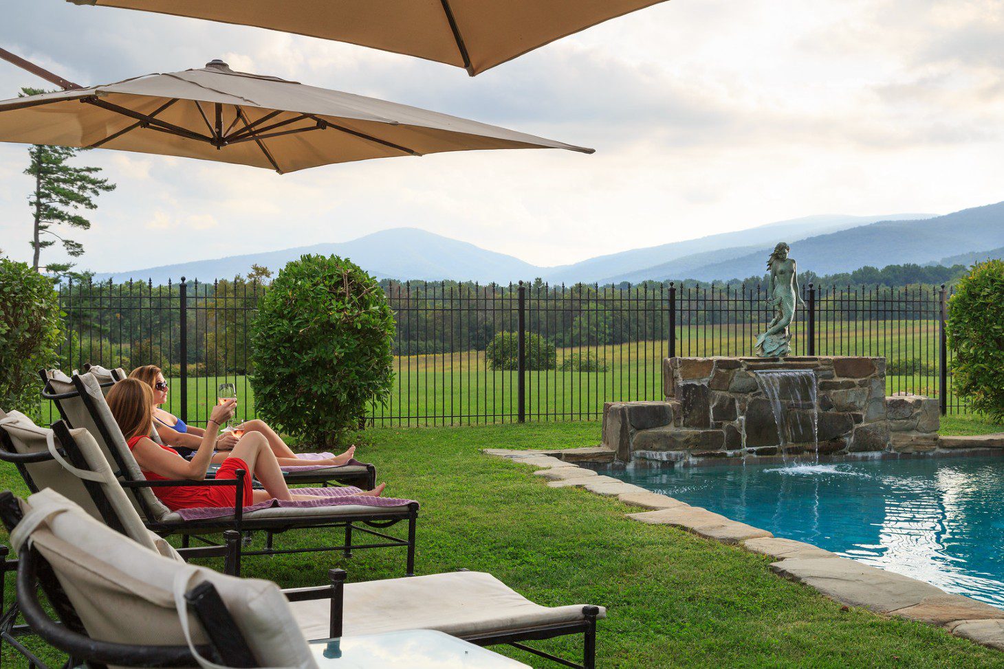 women drinking wine poolside
