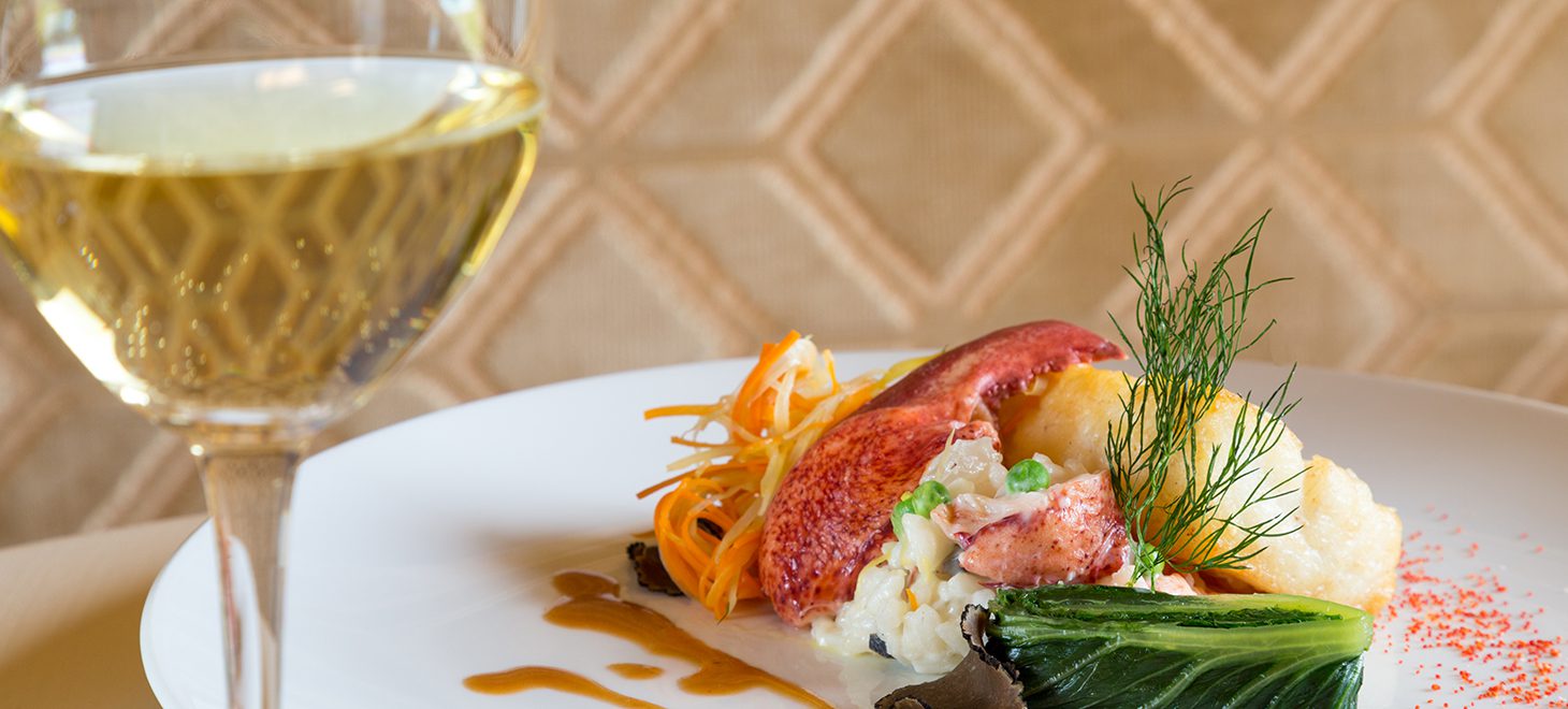 a delectable dish from the houndstooth restaurant with a glass of white wine