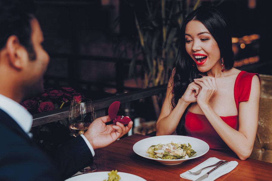 Hispanic Handsome Man Proposing To Girlfriend at a Romantic Virginia Restaurant