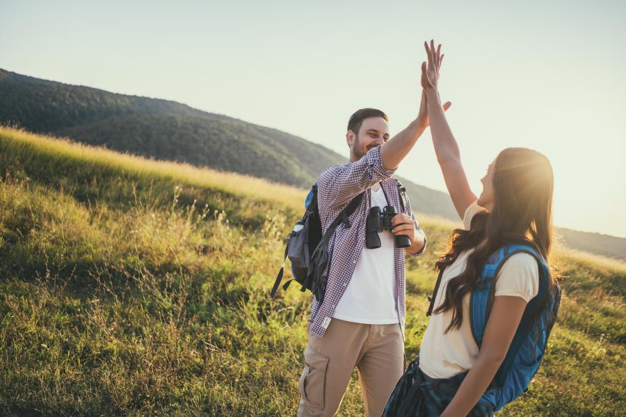 couple giving each other high fives while doing an easy hike