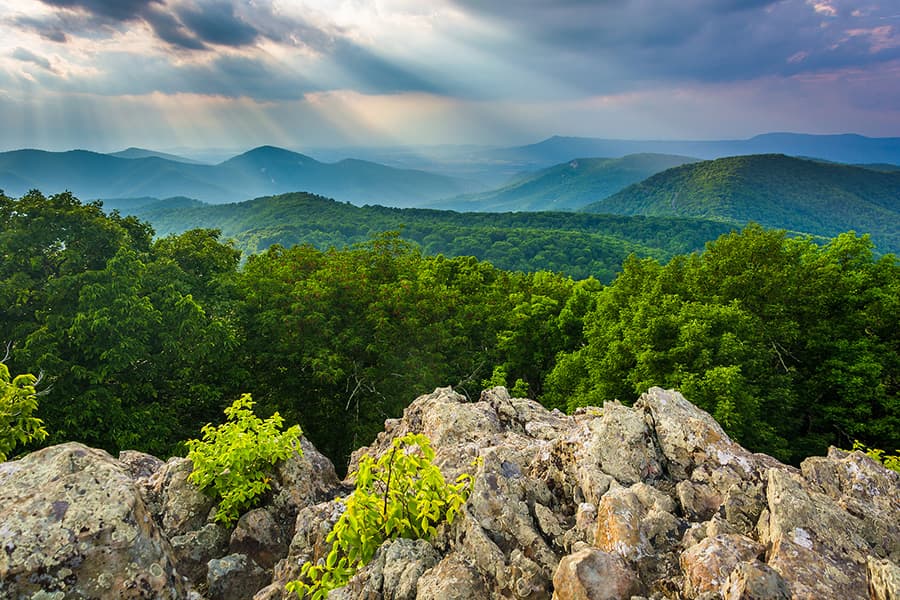 rocky formation overlooking aerial view of mountain range