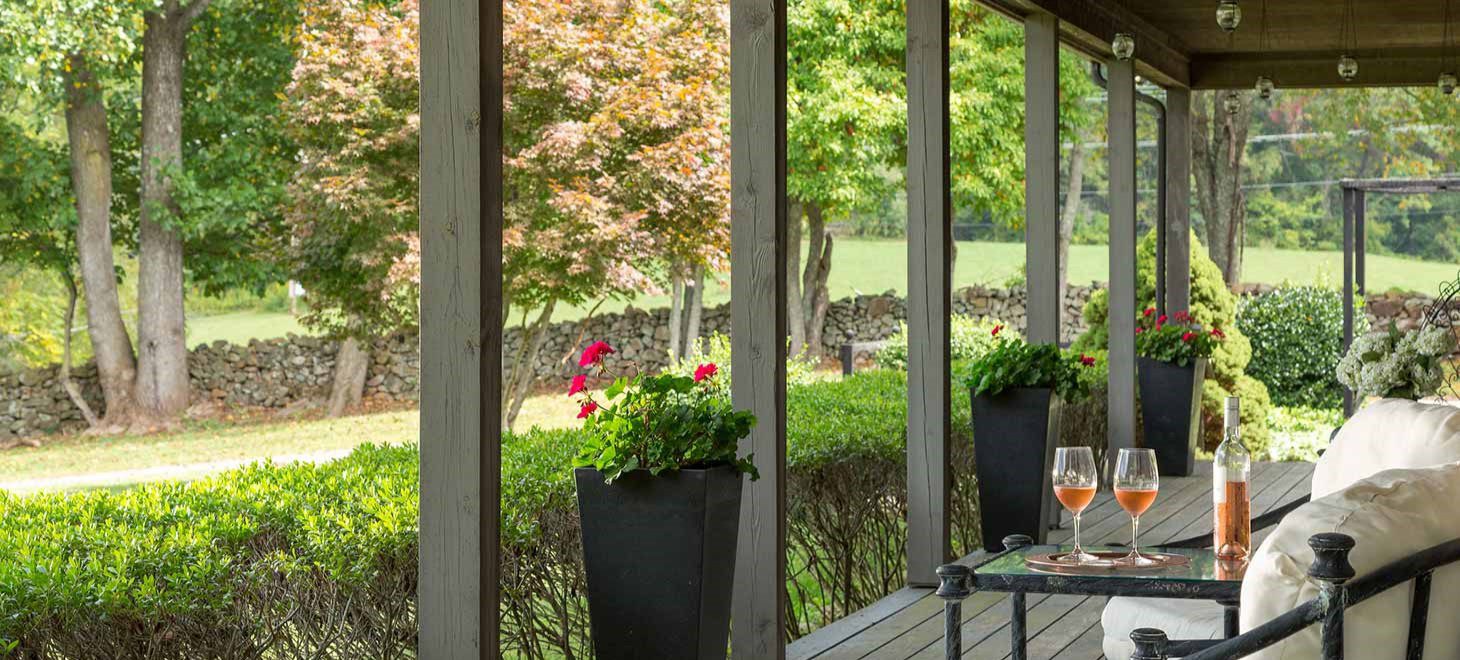 mews cottage porch with a bottle of wine
