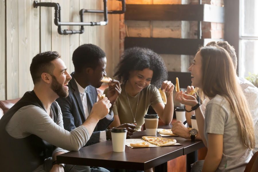 a group of people eating pizza