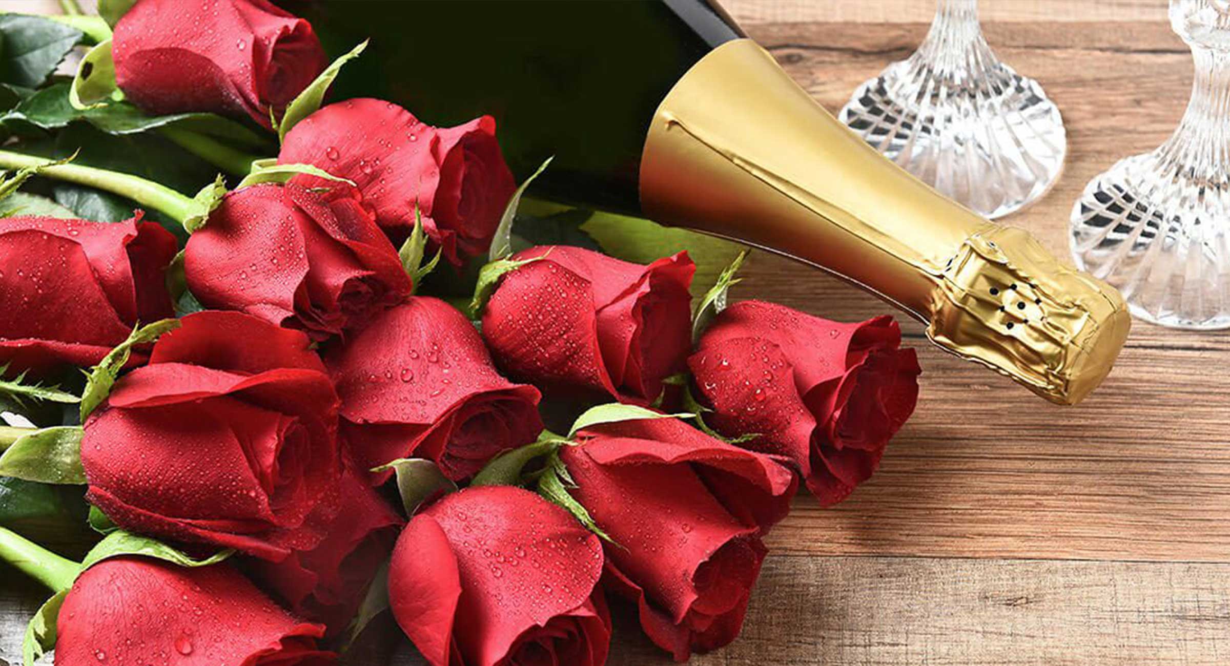 Red roses and bottle of Champagne with two glasses