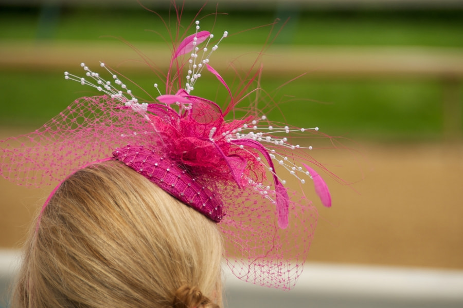 Young blonde woman at a horse racetrack