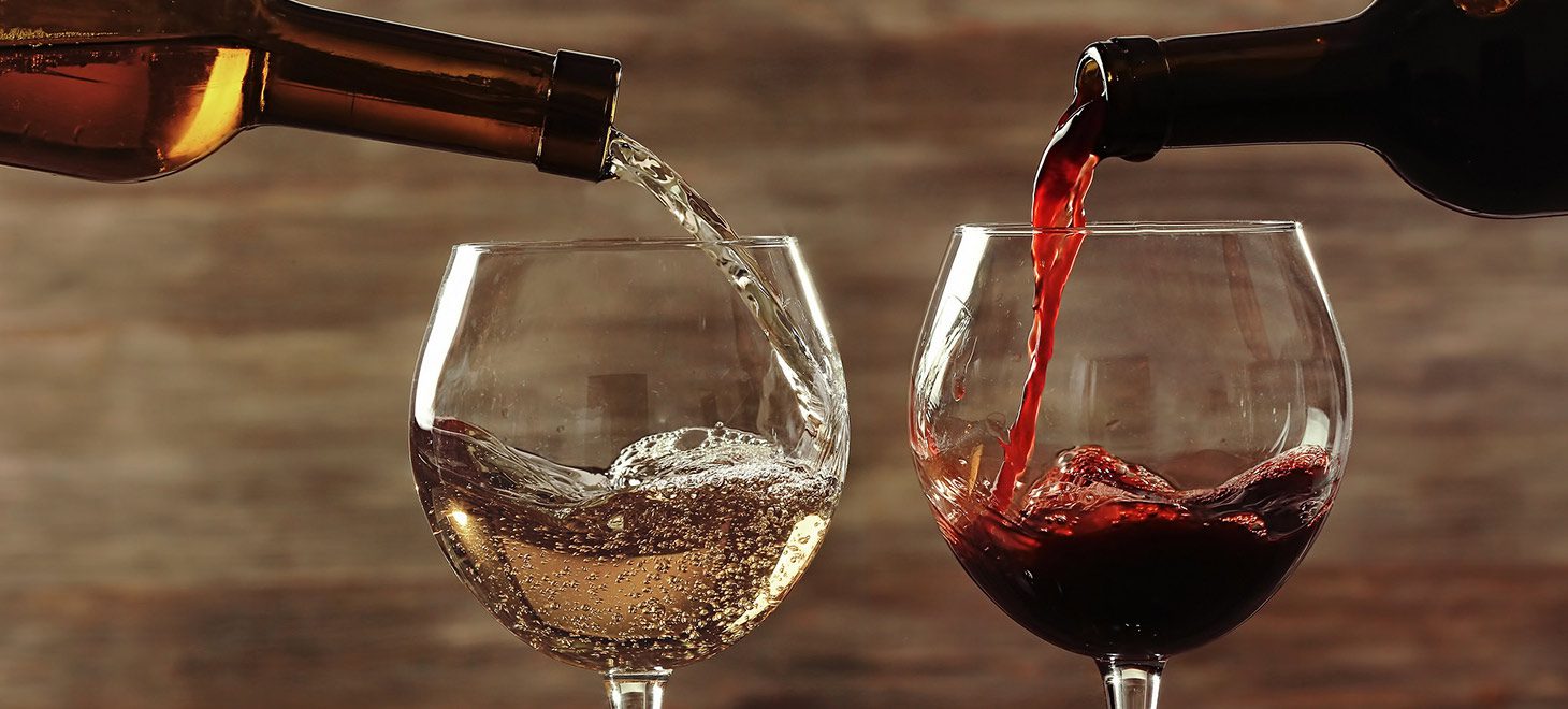 a white and red glass of wine being poured