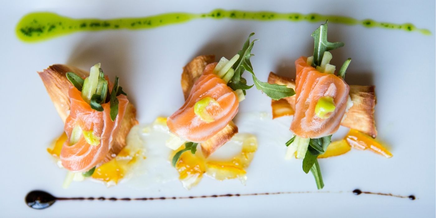 Seasoned salmon entrée by the fireplace at Houndstooth Restaurant, perfect for winter dining